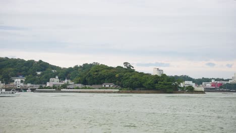 Barco-Pasando-Por-La-Isla-De-Perlas-Mikimoto-En-La-Bahía-De-Toba-En-Un-Día-Nublado-4k