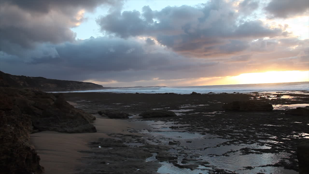impresionante puesta de sol sobre piscinas de roca arenosa cerca de bells beach, australia