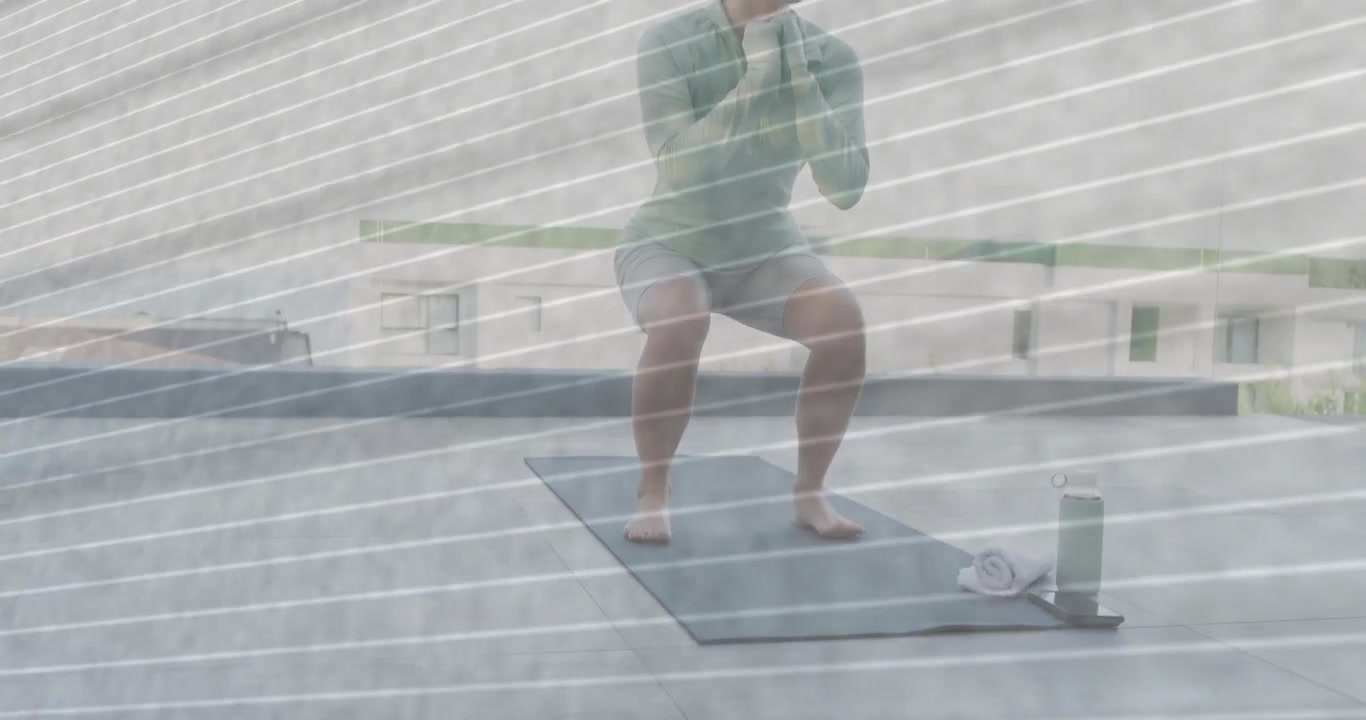 Mulher caminhando sobre um tapete, pisando e fazendo agachamentos controlados com toalha e garrafa para fitness