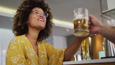 diverse group of happy friends raising glasses making a toast at a bar