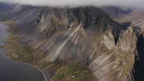 spectacular volcanic mountain ridge covered by large cloud in iceland, aerial