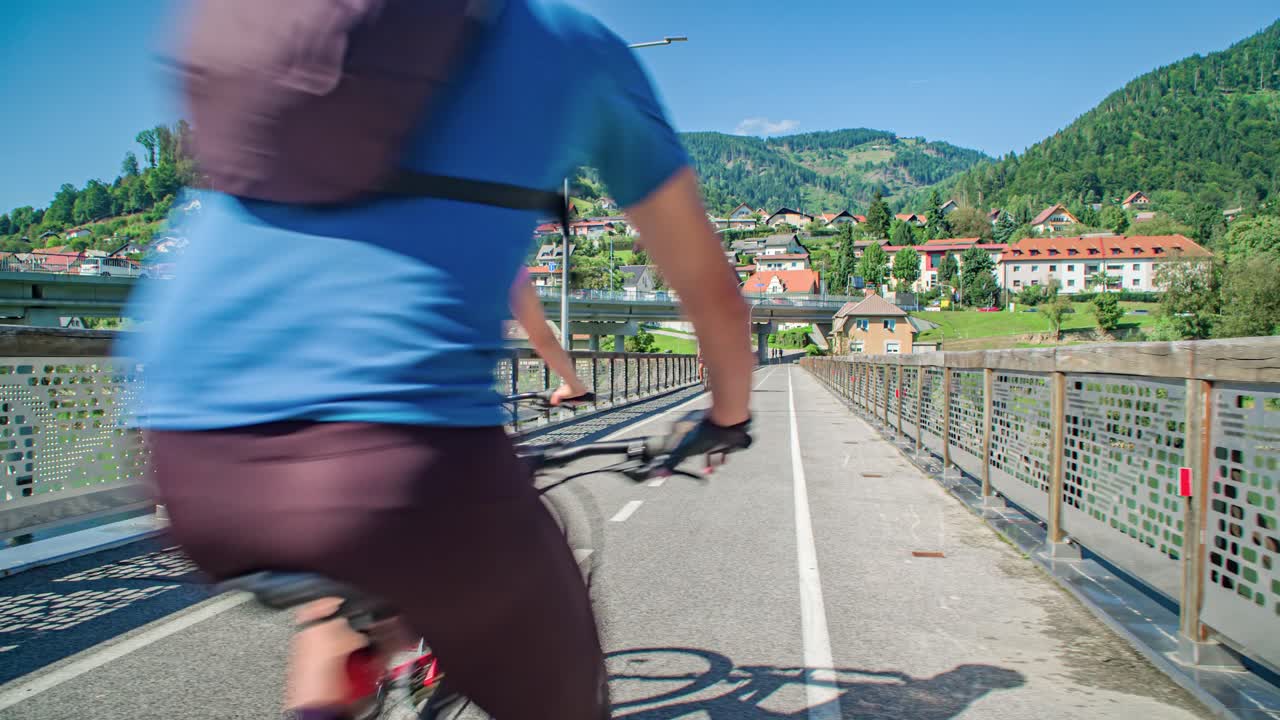 Four of cyclists cheering each other while cycling on bridge, Slovenia