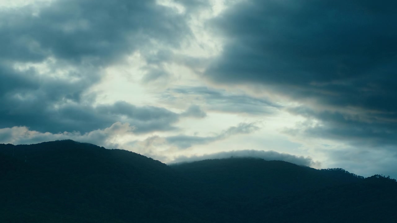 Dark Stormy Clouds Moving Over Mountain Range at Dusk