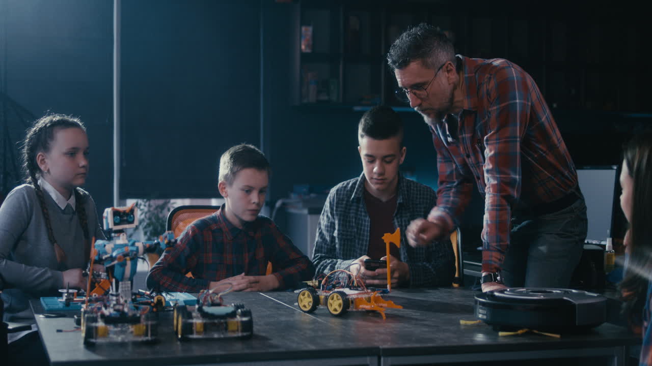 Teacher instructing students on robotics in a classroom