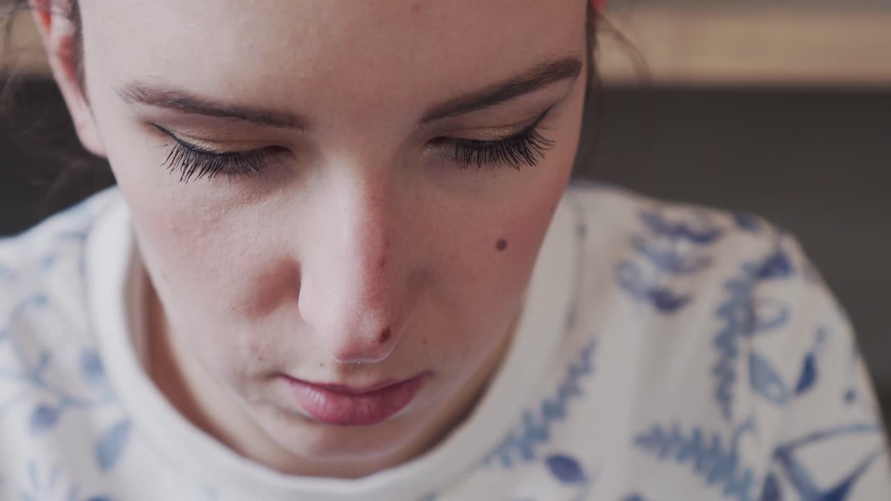 Focused face of young beautiful girl during writing on computer