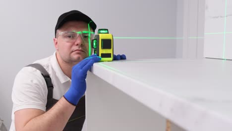 a worker using an electronic laser when assembling furniture a worker using an electronic laser when assembling furniture professional installation of furniture in a new house video