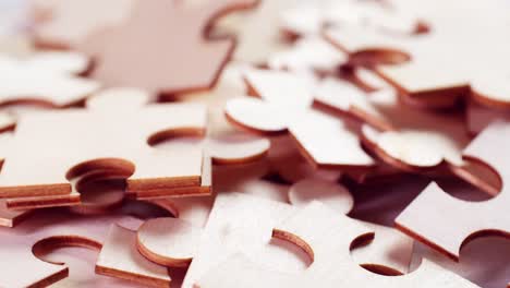 closeup of jigsaw puzzle pieces placed on a turning table revealing pieces exposed to light and creating shadows