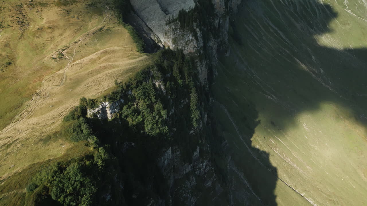Drone aerial view of a mountain ridge on the Diedamskopf (mountain in Austria) in sunny weather. The mountain station of the cable car is visible in the background after the pan.