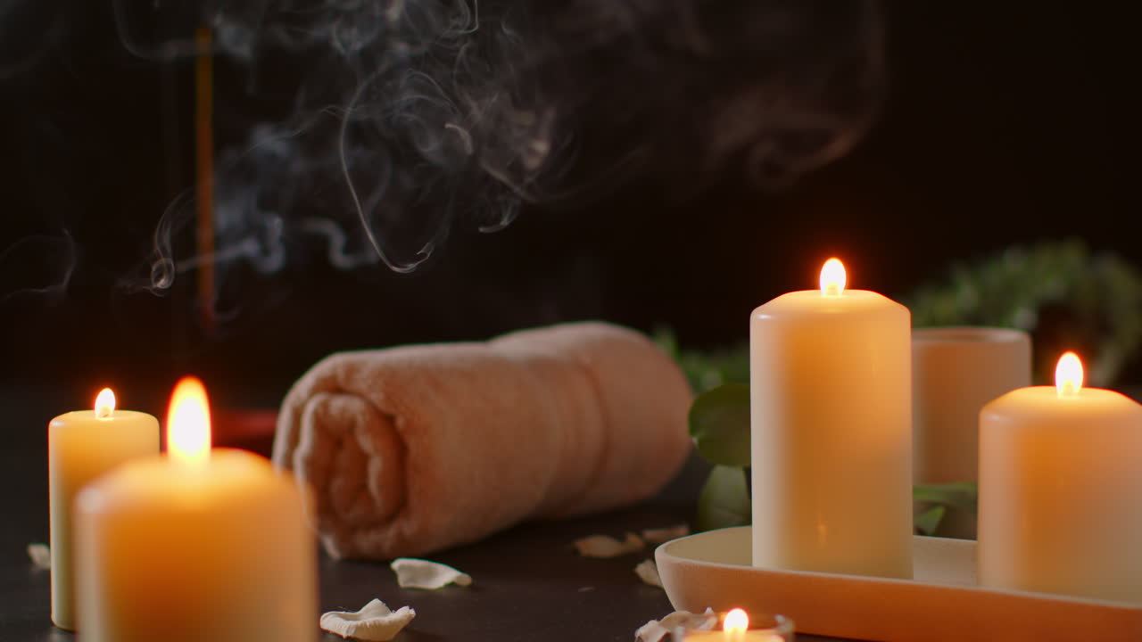 Still Life Of Lit Candles With Green Plant Incense Stick And Soft Towels Against Dark Background As Part Of Relaxing Spa Day Decor 3