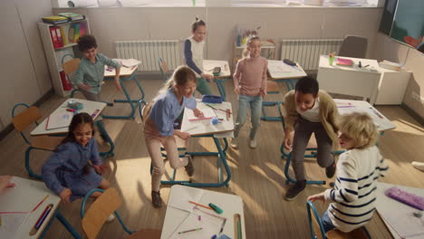 children sitting at school desks. students running from classroom for break