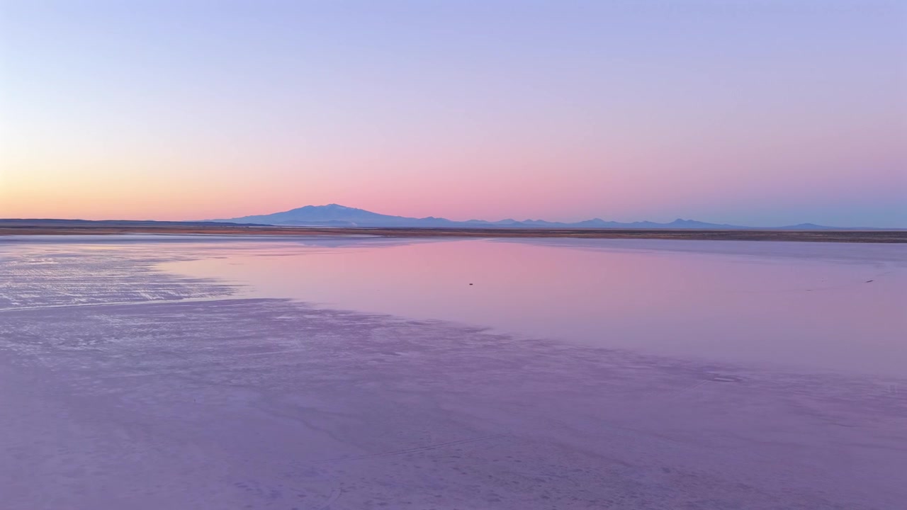 Tramonto dai colori pastello sulle saline di Salinas del Diamante a Mendoza, Argentina, con sfondo panoramico ripreso da drone.