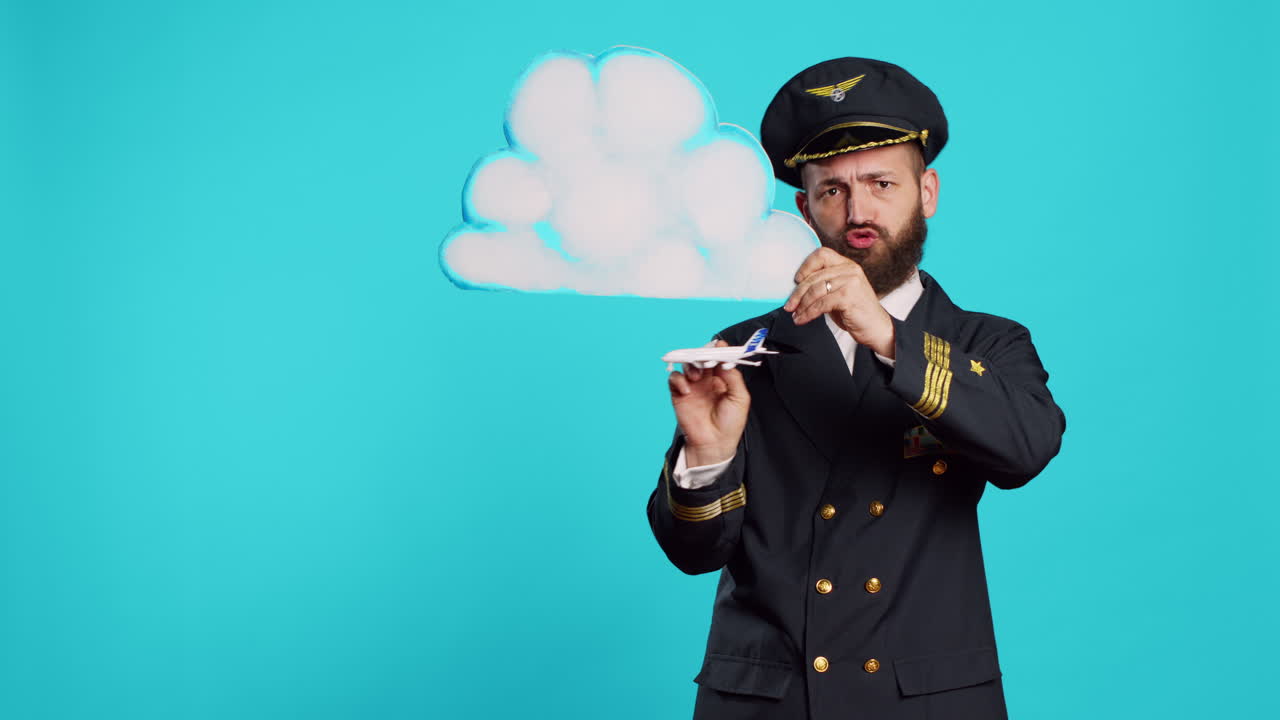 Male aviator playing with airplane toy and cloud board