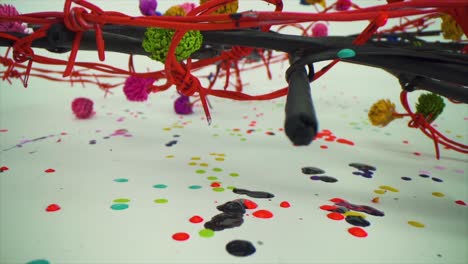 gotas de pintura vibrantes en lienzo blanco con cables retorcidos, arte de colores dejando caer líquidos