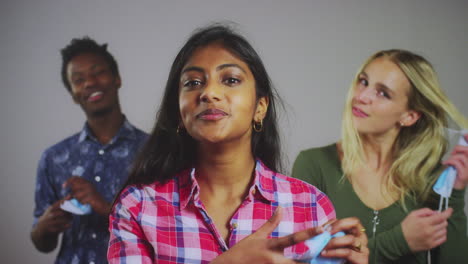 3 young people taking off face masks