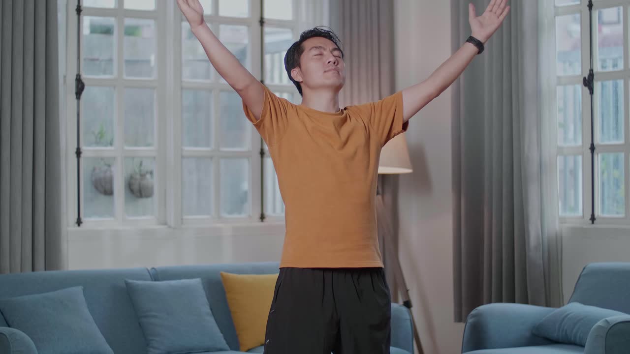 아시아인 남자가 명상에서 요가를 하고 있습니다. sukhasana는 집에서 매트 위에 서서 포즈를 취합니다.