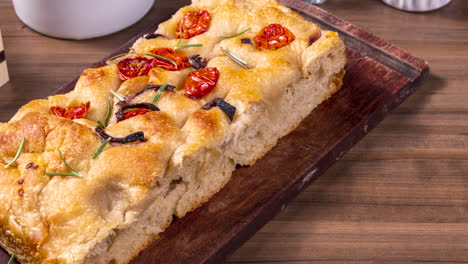 traditional italian focaccia with pepperoni, cherry tomatoes, black olives, rosemary ando onion - homemade flat bread focaccia