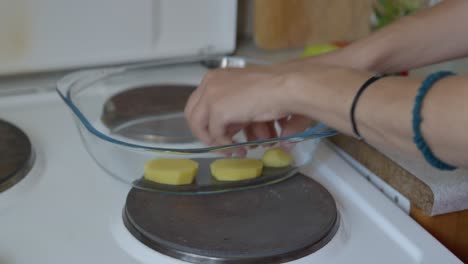 estática, foto de cerca de una mujer colocando patatas en una bandeja de horneado