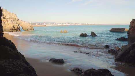 Dreamy-Flowing-Shot-of-a-Rocky-Shoreline-Near-Lagos-Portugal-Transitioning-Into-Cave