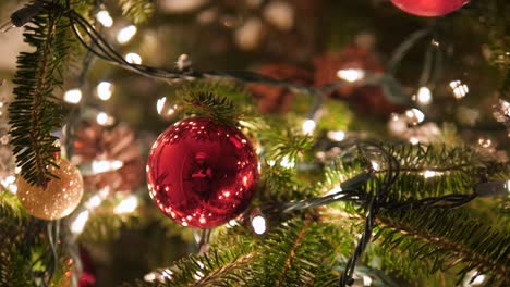 ornaments dangling from christmas tree with bokeh lights