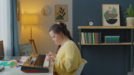 girl with down syndrome playing synth at home