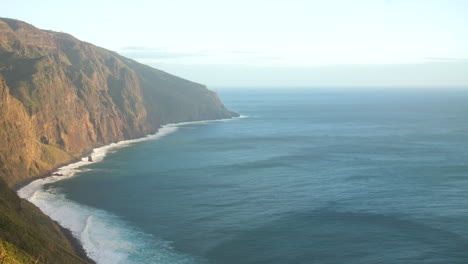 beautiful coastline of madeira powerful ocean waves crashing against rocky cliffs, creating white foam against the deep blue sea, aerial view rugged coastline and the raw, untamed beauty of nature