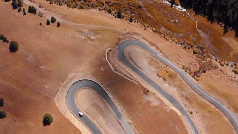 overhead view of a car driving through hairpin turn road