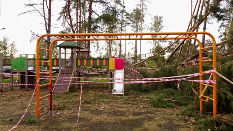 colorful kids playground destroyed by fallen trees after powerful storm