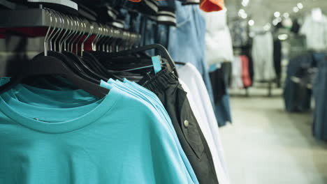 a clothing store displaying a close-up of blue and white clothes neatly hung on hanger.this video highlights the organized display and variety of apparel in a modern retail environment