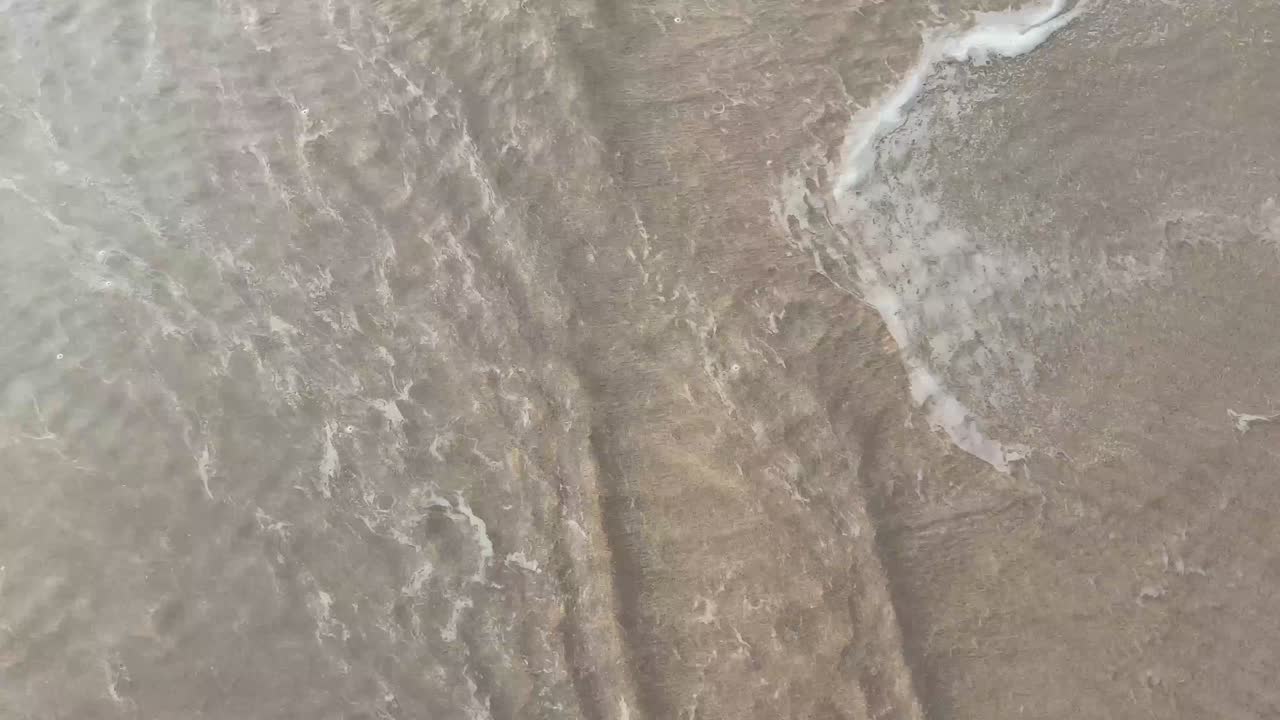 Foto estática aérea de areia molhada na praia