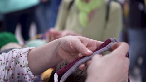 manos trabajando con hilo en una feria de artesanía
