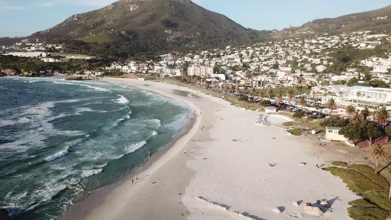 flying over the beach with its waves crashing towards lions head mountain