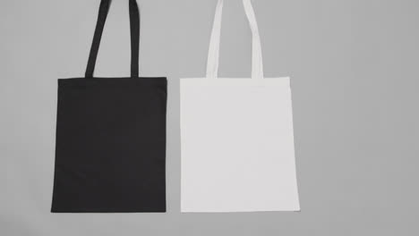 close up of white and black bags on grey background, with copy space, slow motion