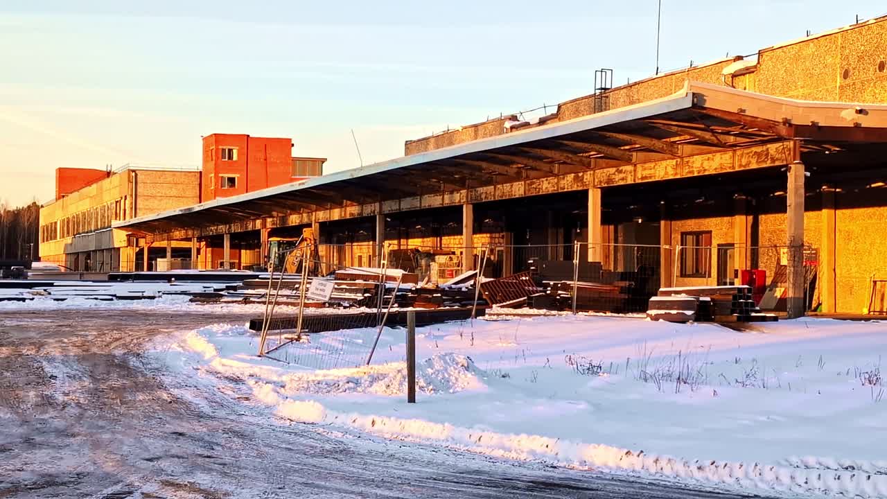 Hylätty tehdasrakennus seisoo lumessa symboloiden hylkäämistä, rappeutumista ja taantumusta.