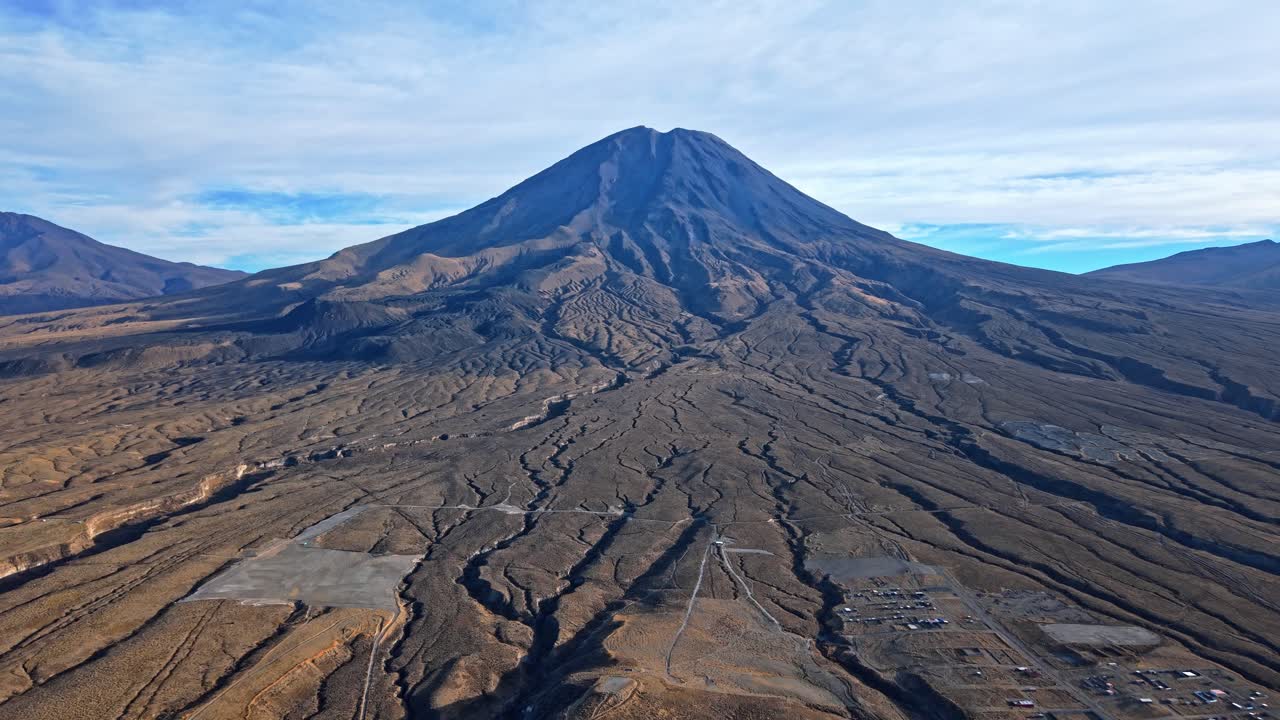 Uma reversão dramática de drone sobre o Monte Misti, no Peru, revela toda a extensão das marcas de lava e das formações geológicas. Um vulcão poderoso domina o quadro, com rastros de lava espalhados que mostram uma história vulcânica poderosa.