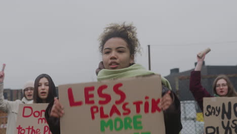 giovane attivista americana che tiene un cartello di cartone contro l'uso della plastica durante una protesta contro il cambiamento climatico