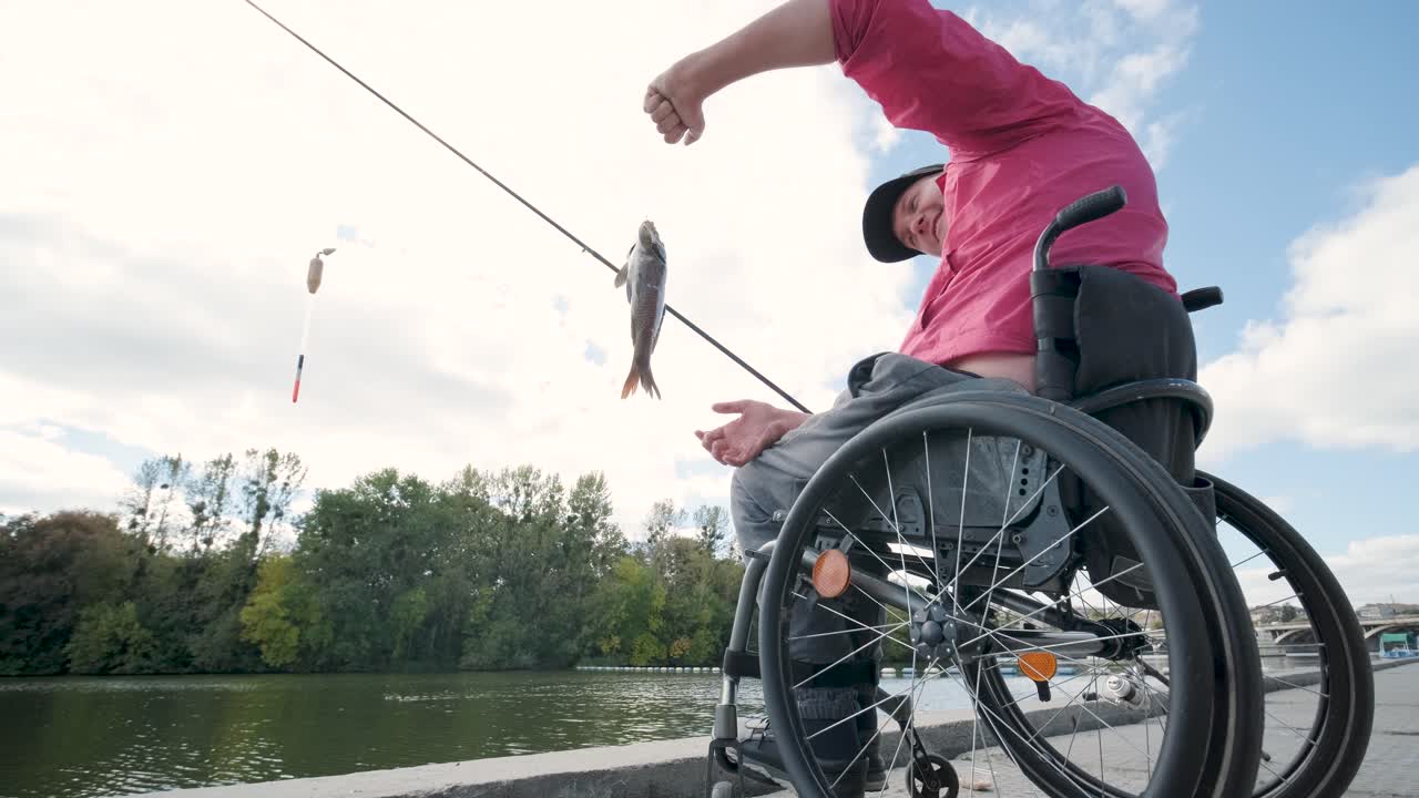 persona con discapacidad física que utiliza silla de ruedas para pescar en el muelle de pesca