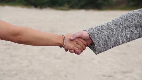 Male Hand reaching out and being taken by young woman's hand