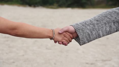 male hand reaching out and being taken by young woman's hand