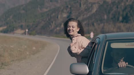 automobile speeds with young woman leaning out car window
