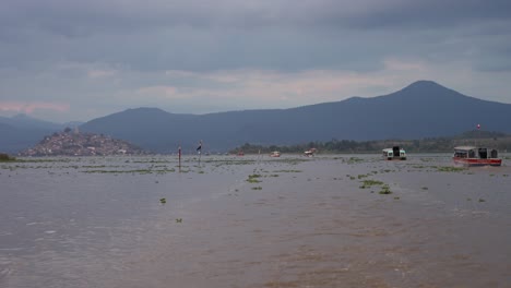 scenic view of lake chapala with boats and distant mountains