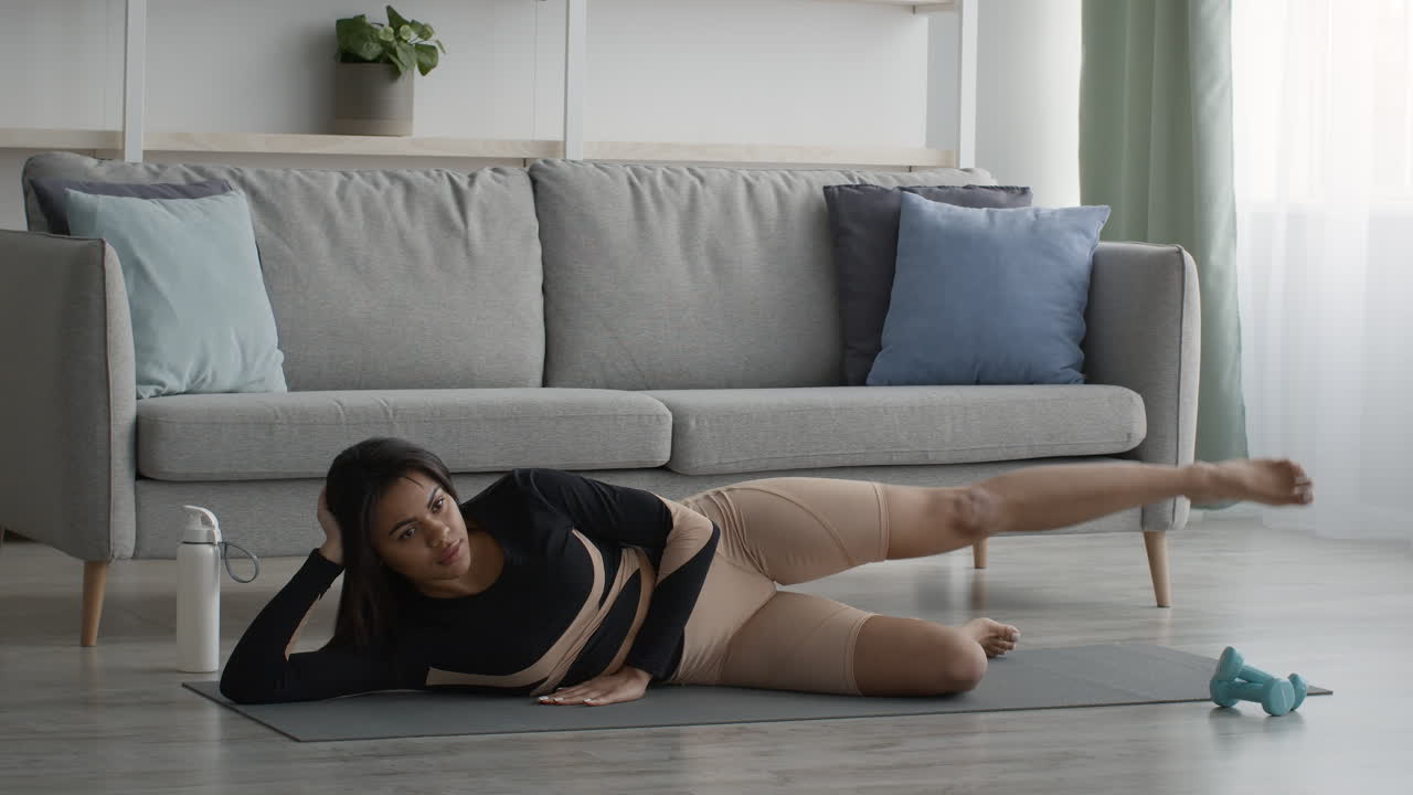 mujer haciendo levantamientos de piernas en casa