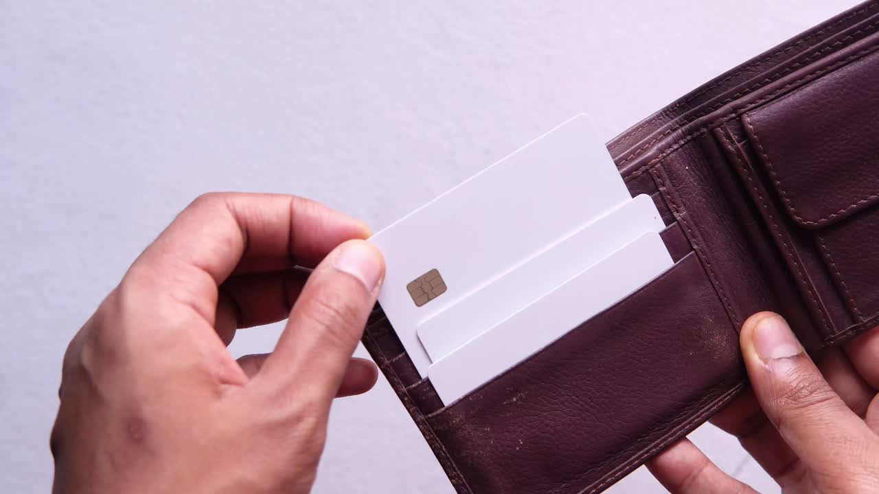 내부에는 빈 신용카드가 들어있는 갈색 가죽 지갑을 열고 있습니다.