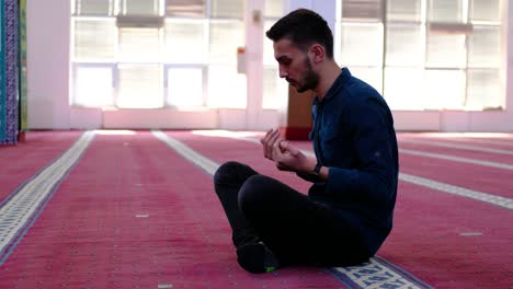 man raising his hands praying mosque