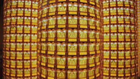 a symmetrical close-up of golden buddha statues glowing in individual illuminated niches at ciyou temple in taiwan, symbolizing devotion, peace, and spiritual reverence in a sacred buddhist space