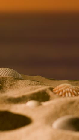 Vertikales-Video-Sommerferienkonzept-Mit-Muscheln-Seesterne-Am-Sandstrand-Gegen-Meer-Und-Sonnenuntergang-Himmel