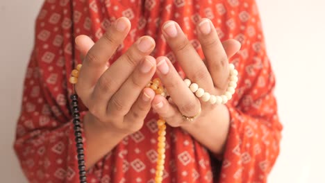 woman praying with prayer beads