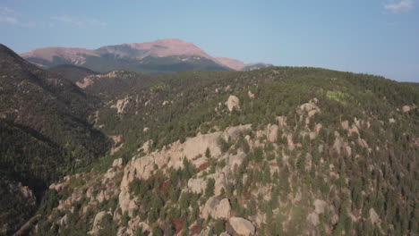 Aerial-dolly-in-over-rugged-Colorado-mountains,-looking-towards-Pikes-Peak