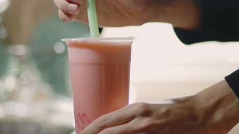 Strawberry-Milk-Bubble-Tea---Man-Put-Drinking-Straw-On-Tea-Based-Drink-In-A-Restaurant