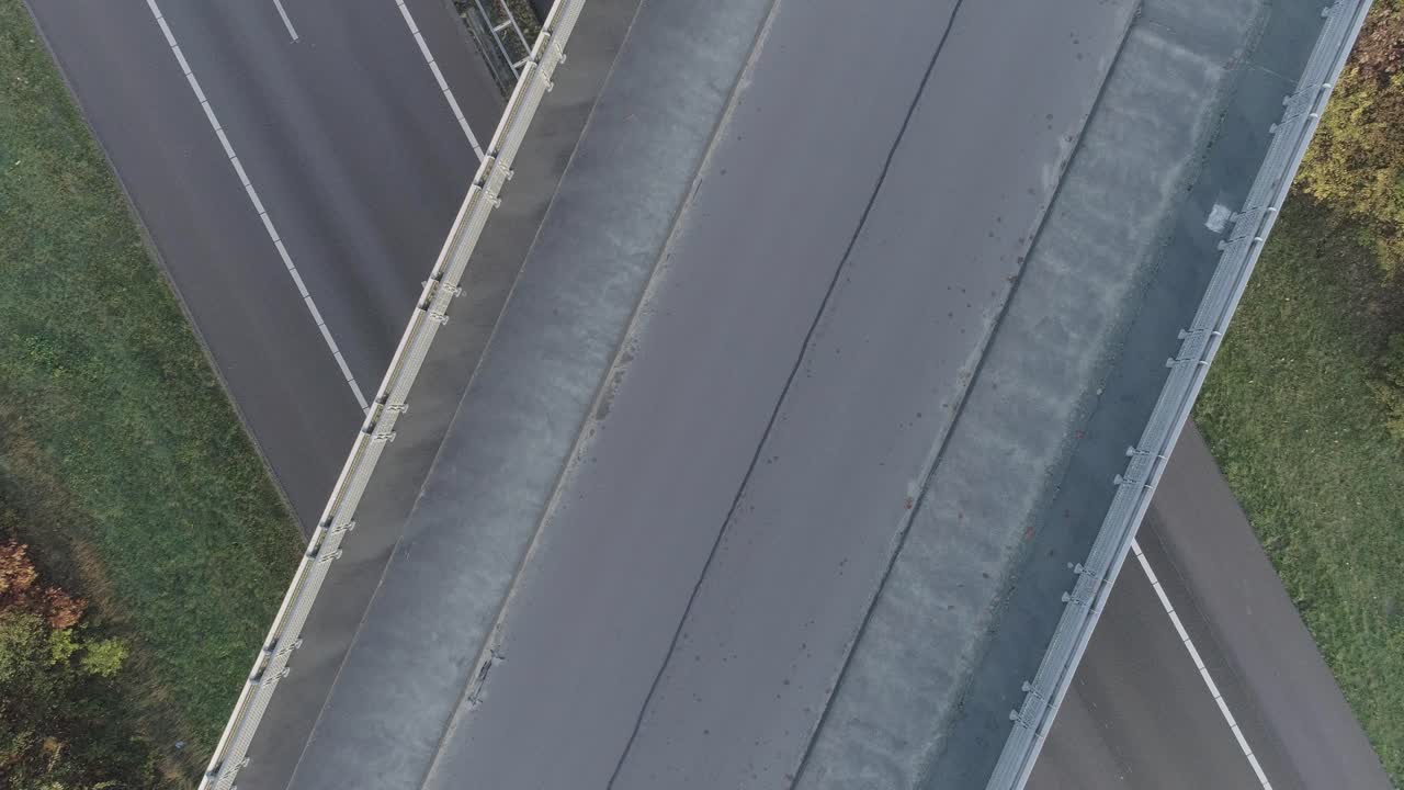 Ripresa aerea con drone di un grande svincolo stradale e autostradale, con un mountain biker che passa sotto