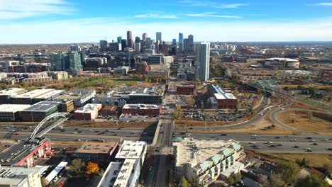 aerial drone video of downtown denver city skyline with i-25 highway and cars driving in the foreground